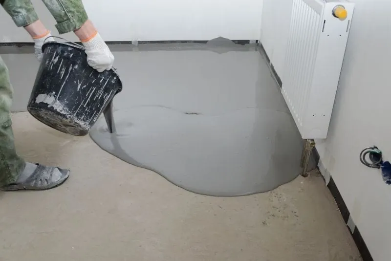 Pouring epoxy resin mixture onto a floor before spreading