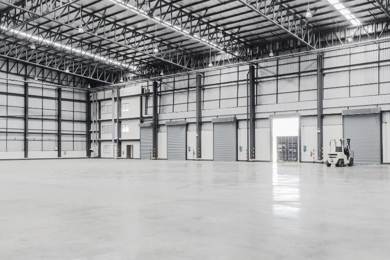Large empty warehouse interior with a sealed pale epoxy floor