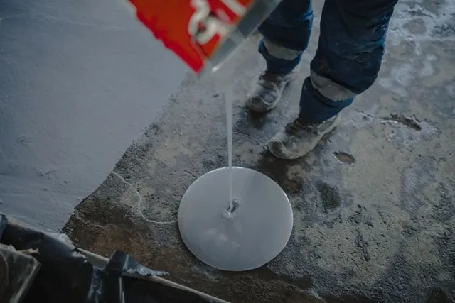 Epoxy resin being poured onto a prepared concrete floor