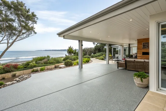 Covered outdoor entertaining area with a slip-resistant floor coating overlooking the water